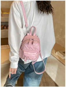 Detail of pink mini backpack featuring heart quilted pattern and adjustable straps
