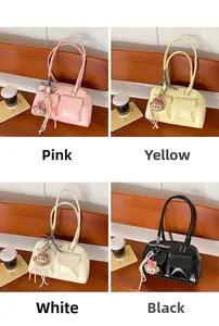 Detail view of four vintage Boston bags in pink, yellow, white, and black with charms