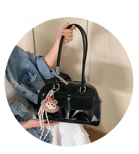 Detail of vintage black Boston bag with dual pockets and cute plush charm accessory