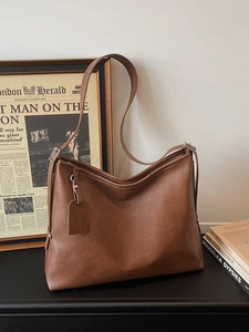 Brown vintage faux leather tote bag with large capacity for women on retro background