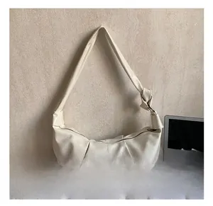 Detail of pleated shoulder bag with knot strap and zip closure in beige faux leather