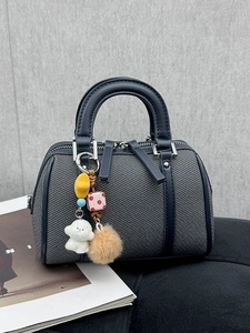 Sac Boston en toile bleu foncé avec garniture en cuir et breloque chien sur fond gris