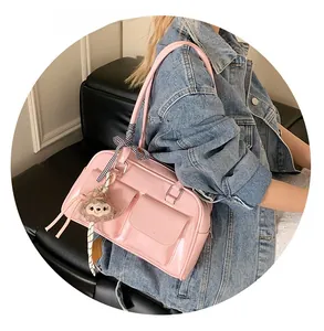 Pink patent leather Boston bag with a plaid ribbon and plush charm on a side-view model