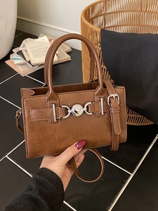 Brown leather crossbody bag with silver heart buckle and round top handles