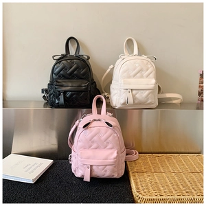 Detail of quilted mini backpacks with bow accents and heart stitching in three colors