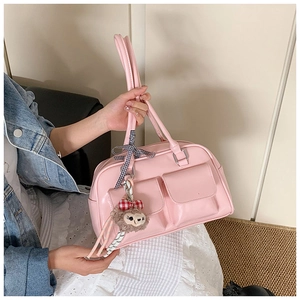 Pink Boston bag detail featuring dual front pockets and decorative plush bear charm