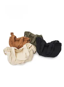 Flat lay detail of canvas tote bags in cream, tan, green, and black with zipper closure