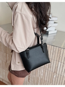 Detail of black lychee grain leather tote bag showing texture and silver hardware details