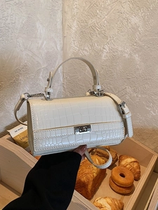 Elegant cream crocodile-embossed handbag with silver twist lock and crossbody strap