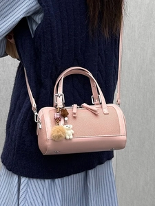 Pink Boston bag with plush bear charm, worn by model over shoulder in a stylish view