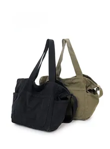 Detail of large canvas tote bags in black and army green with side pockets and strap
