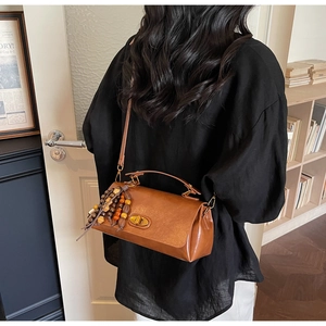 Détail du sac à main rétro marron avec fermoir doré et perles en bois colorées