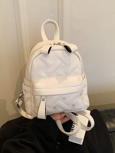 Versatile cream heart-quilted leather mini backpack for women shown in hand