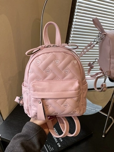 Pink quilted mini backpack with heart embroidery shown in a stylish handheld mirror reflection