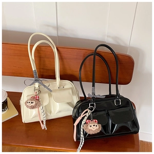 Detailed view of vintage high-gloss PU leather shoulder bags with bow and plush pendant