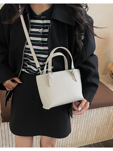 Chic cream-white pebbled leather handbag shown being worn by a model in a medium shot