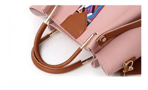Dettaglio borsa in ecopelle rosa con manico in metallo dorato e nastro colorato intrecciato