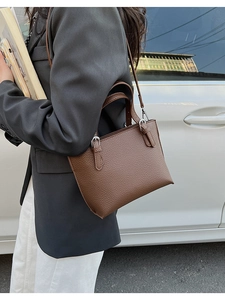 Close-up of dark brown pebble leather handbag featuring silver hardware and a slim strap