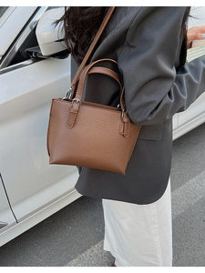 Brown lychee-textured leather mini tote bag shown during outdoor street photography