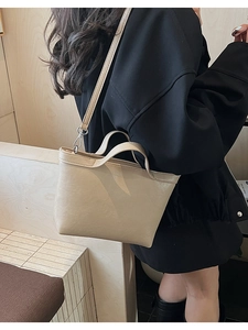 Detail of cream beige mini tote bag with matte leather texture and silver hardware hooks
