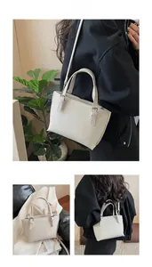 Detail of off-white lychee texture leather tote with adjustable strap and silver buckle