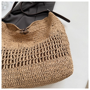 Détail d'un sac bohème tissé avec texture en tricot et bandoulière en cuir brun