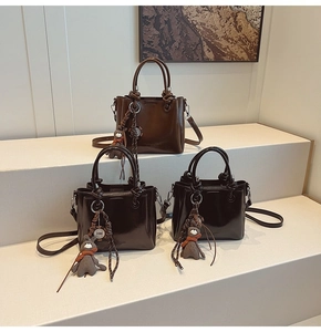 Bolsos de cubo en cuero sintético marrón y negro con asas anudadas y colgantes de conejo