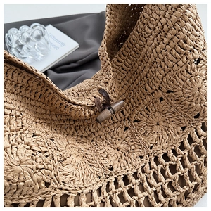 Détail du sac cabas tissé main avec fermoir en bois et texture ajourée élégante