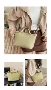 Detail view of avocado green crossbody bag with top handle and adjustable strap for daily commute