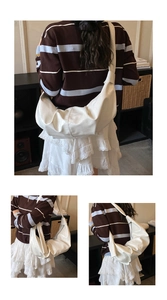 Detail view of large white hobo bag with integrated shoulder strap and pleated design