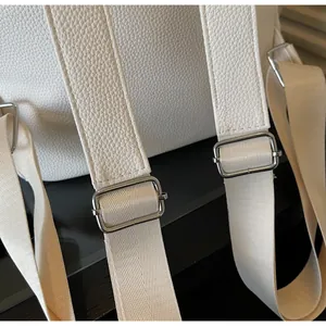 Detail of adjustable white leather strap with silver buckle on the stylish backpack