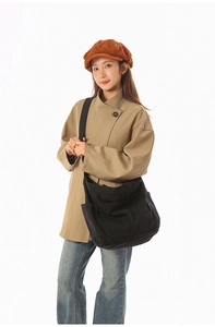 Detail of black canvas tote bag with side pocket and adjustable wide shoulder strap