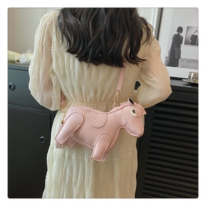 Detail of pink horse-shaped crossbody bag featuring tassel tail and gold hardware