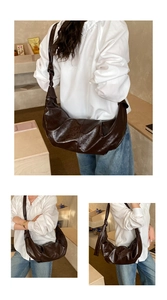 Detail view of dark brown oil wax leather crescent bag with knot shoulder strap details