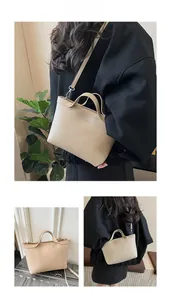Detail of minimalist beige tote bag with litchi grain texture and silver metal hooks