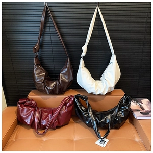 Close-up of pleated dumpling bags in four colors with glossy oil wax leather textures
