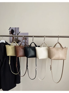 Detailed display of five colorful faux leather crossbody bags hanging in a row