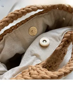 Détail du fermoir magnétique doré sur un sac de plage tissé avec doublure coton