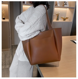 Detailopname van de caramelbruine leren shopper met groot voorvak en matte afwerking