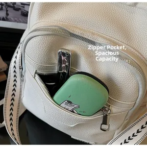 Close-up of front zipper pocket on white lychee leather backpack showing large storage space