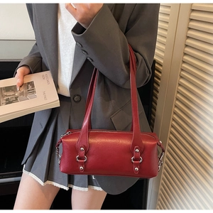 Detail view of burgundy leather pillow bag with silver hardware on shoulder