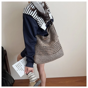 Détail d'un sac cabas tissé avec texture ajourée et fermeture à bouton en bois