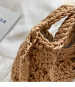 Détail du sac seau tissé kaki avec crochets en métal doré et texture au crochet