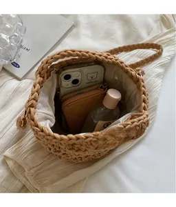 Détail du sac seau marron tressé montrant l'intérieur spacieux et la doublure