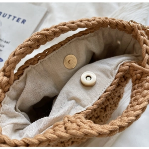 Gros plan d'un sac en paille fait main avec texture crochetée et fermoir magnétique
