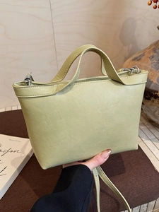 Minimalist light green PU leather trapezoid handbag with dual handles and shoulder strap