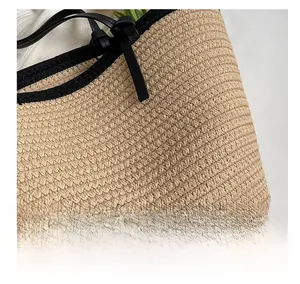 Macro detail of handwoven beige straw texture with elegant black leather edge and strap