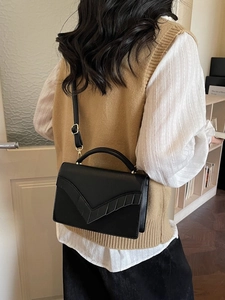 Sac à bandoulière minimaliste en cuir noir avec rabat en V et détails dorés élégants