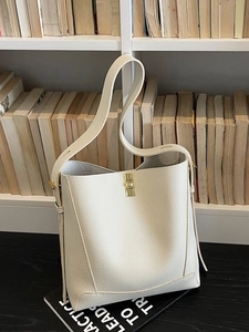 Minimalistische beigefarbene Beuteltasche aus Leder mit goldenem Drehverschluss und Schultergurt