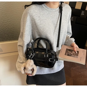 Vue latérale du mini sac bowling en cuir verni noir brillant avec breloque lapin en peluche